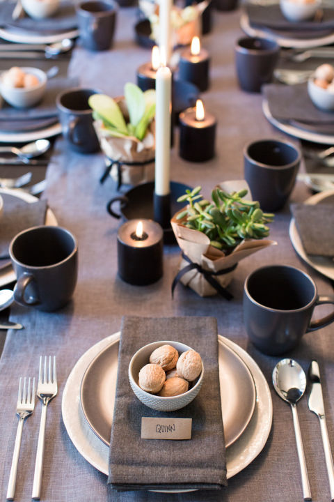 Темная тема оформления стола с изюминкой в виде растений в мини-горшочках и свечах